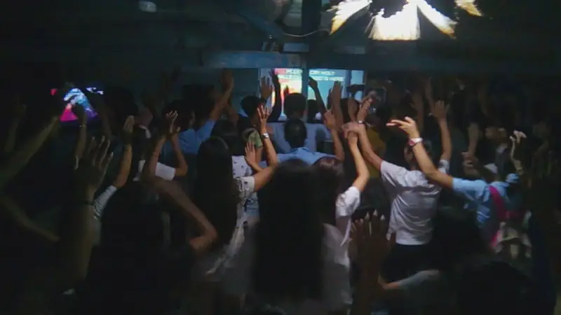 Students worshipping with hands raised